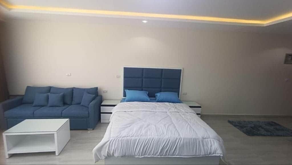 Comfortable bedroom with a double bed, blue headboard, and modern furnishings.