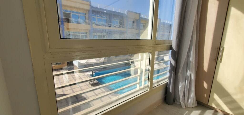 View from the apartment window showing the swimming pool outside.