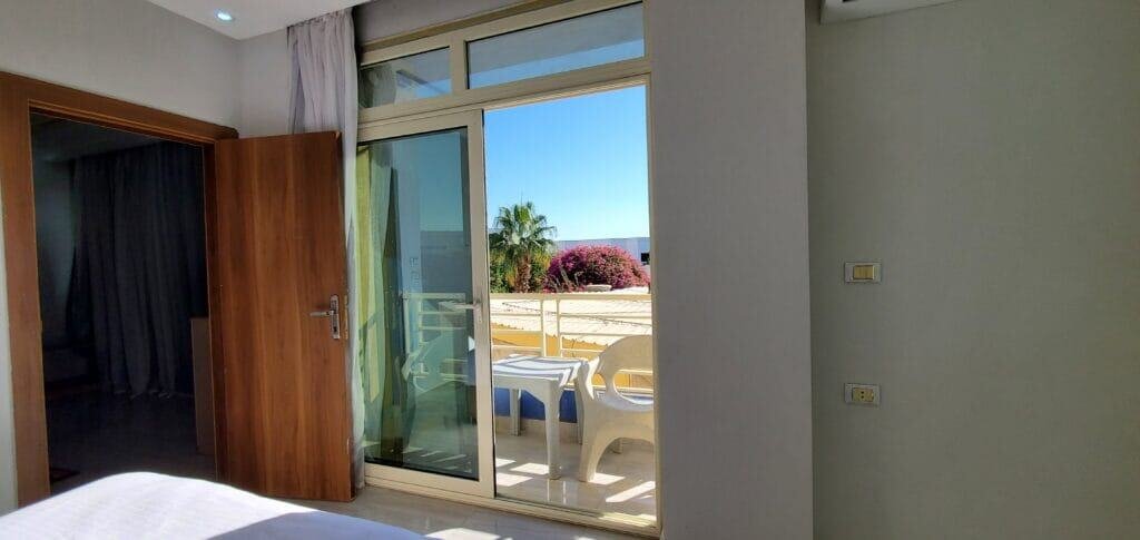 Balcony with outdoor seating overlooking the sea and palm trees in Hurghada, Egypt. Perfect for rela.