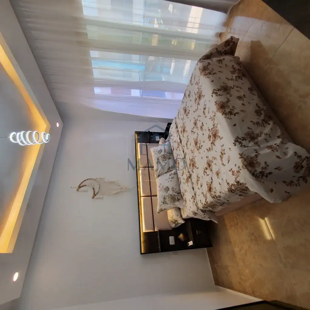 Elegant bedroom with floral bedding and stylish decor in a holiday apartment.
