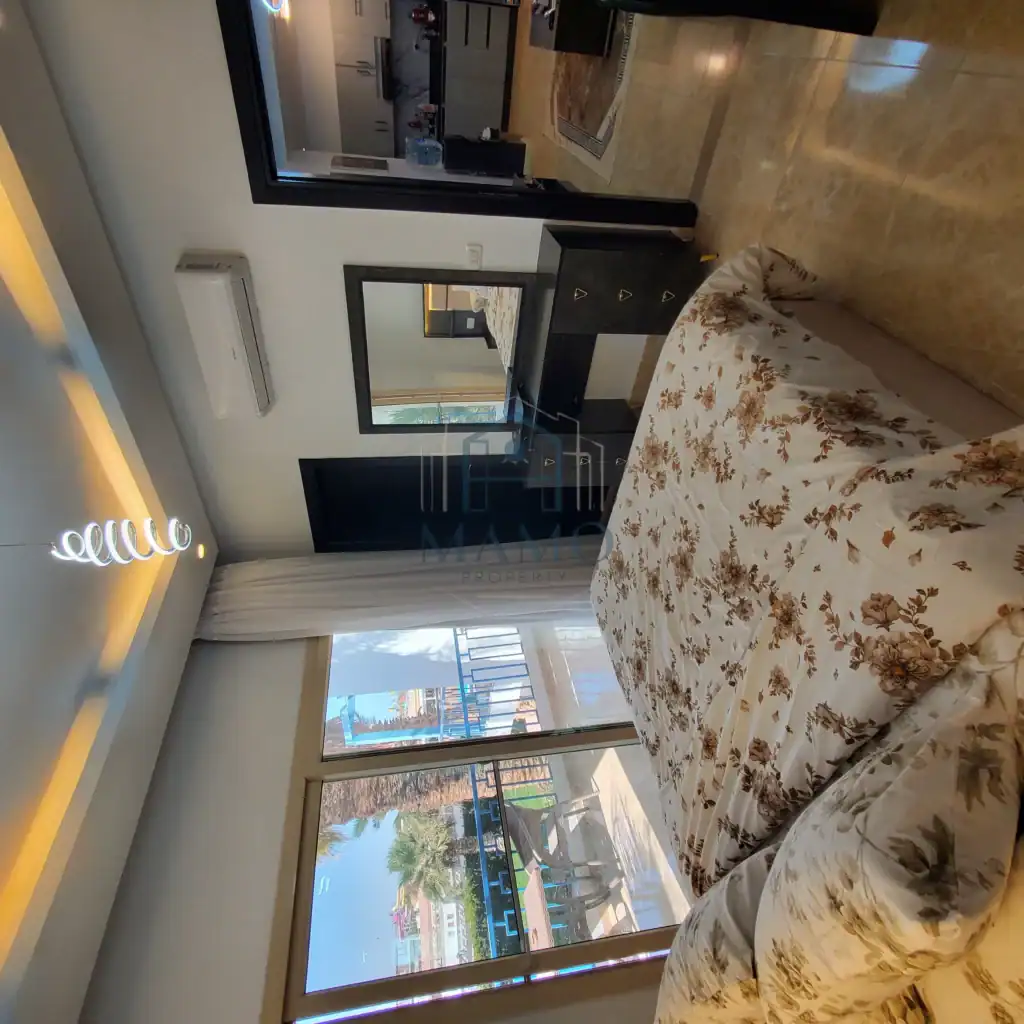 Bright bedroom with balcony overlooking Hurghada cityscape.