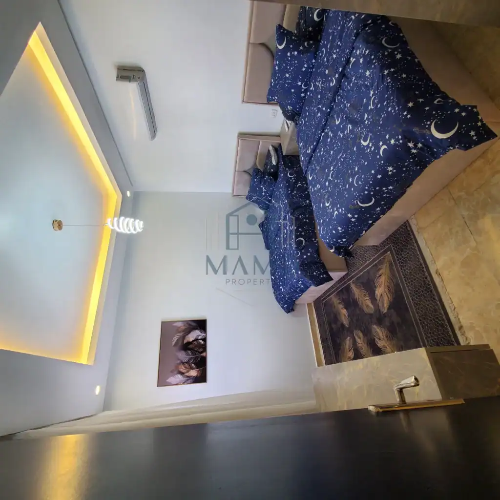 Cozy bedroom featuring celestial-themed bedding and modern decor in a vacation rental in Hurghada.